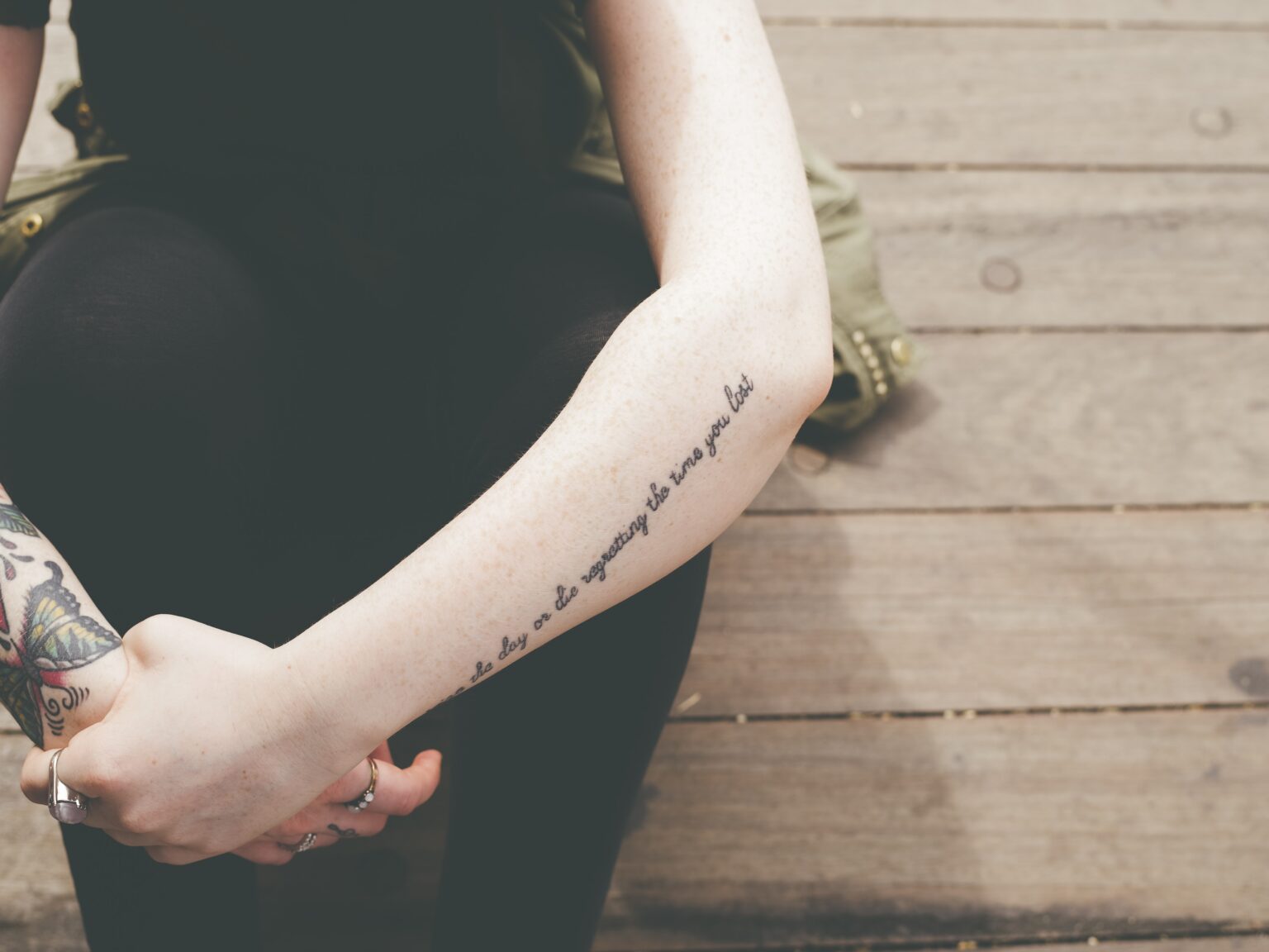 a photo of a young woman's tattooed arms