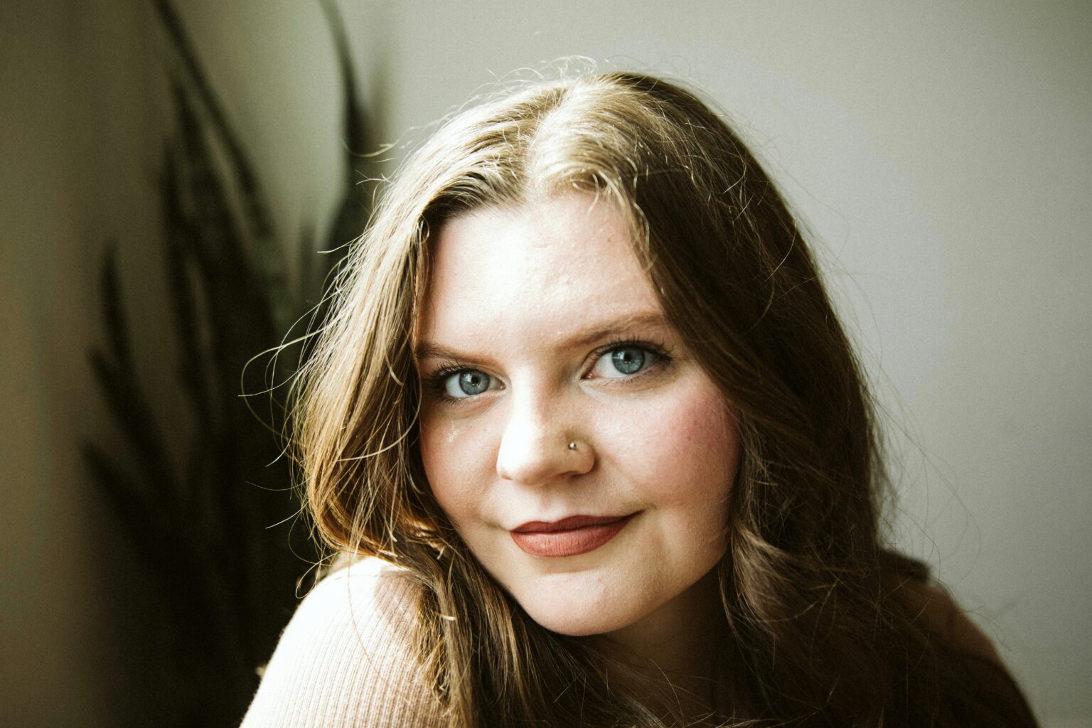 woman in cream sweater smiling at camera